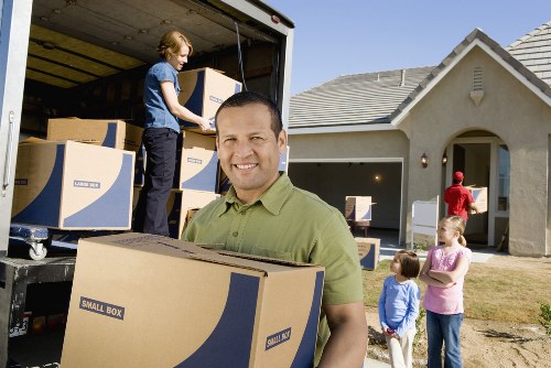 Home movers carrying furniture through a Richmond property